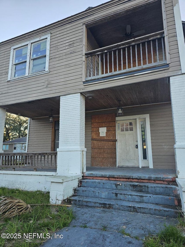 exterior space featuring brick siding, a porch, and a balcony