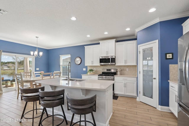 kitchen featuring light countertops, wood finish floors, appliances with stainless steel finishes, and a sink