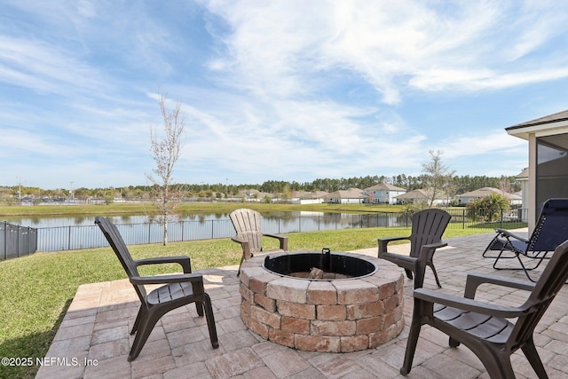 view of patio featuring fence, a water view, and an outdoor fire pit