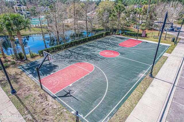 view of sport court featuring community basketball court, fence, and a water view