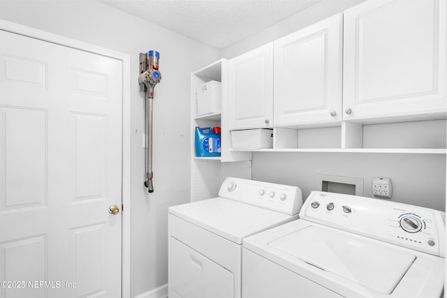 laundry room with cabinet space, washing machine and dryer, and a textured ceiling