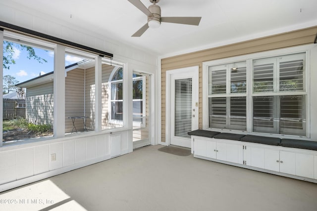 unfurnished sunroom with ceiling fan