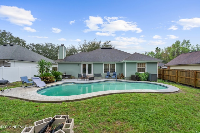 view of pool with a patio, a fenced in pool, a yard, a fenced backyard, and french doors