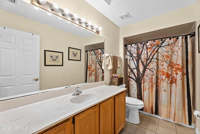 bathroom with tile patterned floors, visible vents, toilet, a textured ceiling, and vanity