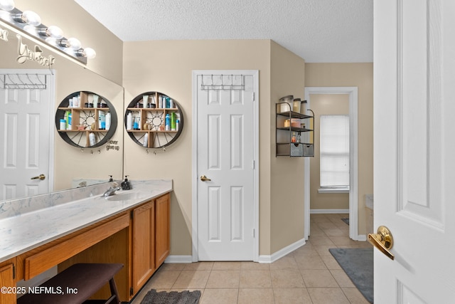 bathroom featuring tile patterned flooring, a textured ceiling, vanity, and baseboards