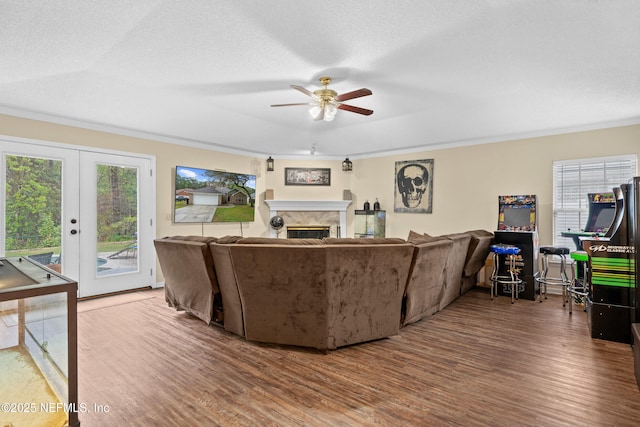 living area featuring plenty of natural light, wood finished floors, a fireplace, and crown molding