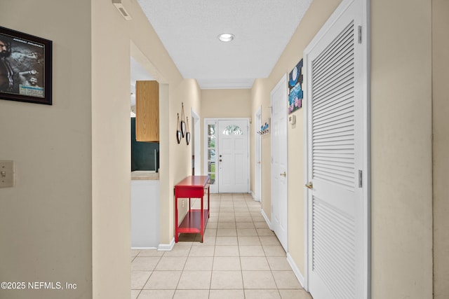 hallway featuring light tile patterned floors and baseboards