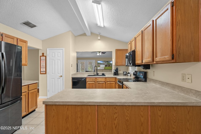 kitchen with visible vents, black appliances, a sink, a peninsula, and light tile patterned floors