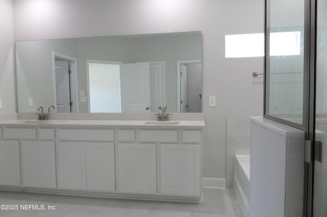 bathroom with a sink, a garden tub, and double vanity