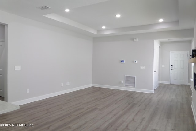 spare room featuring a tray ceiling, recessed lighting, and visible vents