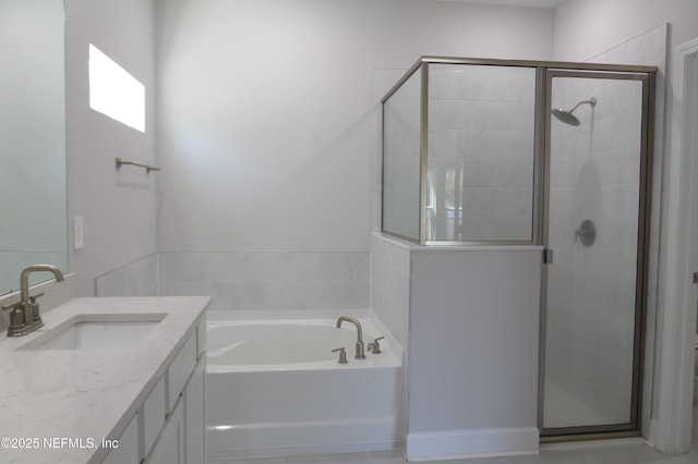 bathroom with vanity, a garden tub, and a stall shower