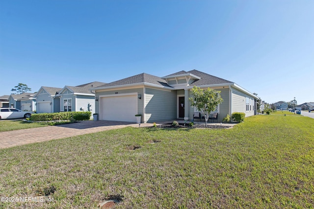 view of front of home with a residential view, a front lawn, decorative driveway, and a garage