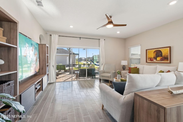 living room with recessed lighting, wood finished floors, visible vents, and a wealth of natural light