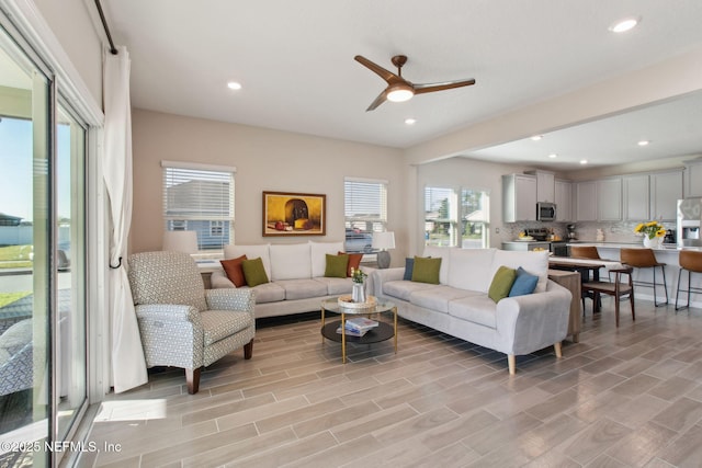 living room featuring a ceiling fan, recessed lighting, and wood finish floors