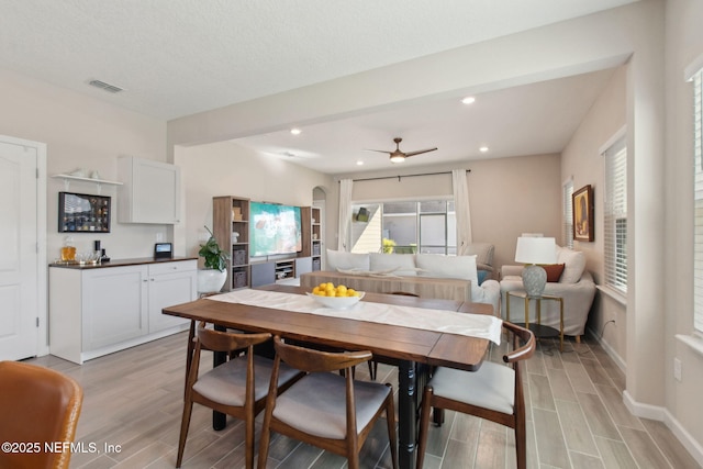 dining space with visible vents, ceiling fan, wood tiled floor, recessed lighting, and arched walkways