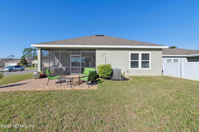 back of property featuring central air condition unit, a patio, fence, a yard, and a sunroom