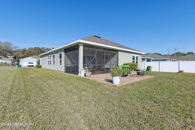 rear view of house with a patio area, a sunroom, a lawn, and fence