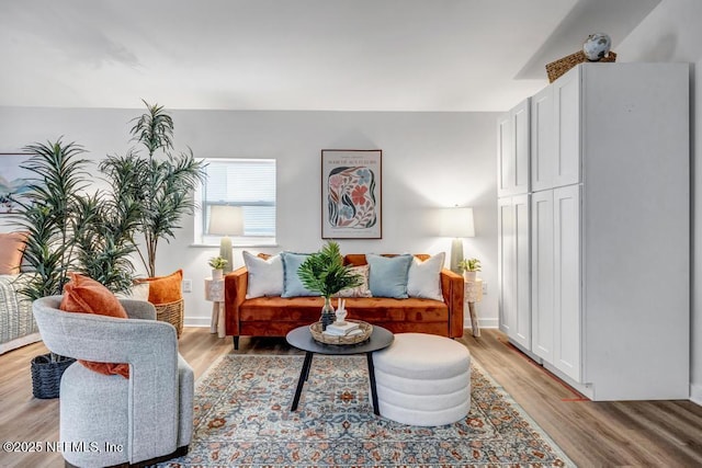 living area featuring baseboards and light wood-style floors