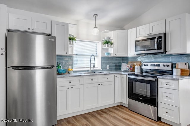 kitchen featuring open shelves, a sink, vaulted ceiling, appliances with stainless steel finishes, and white cabinetry