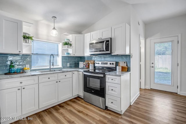 kitchen with open shelves, white cabinetry, appliances with stainless steel finishes, and a sink