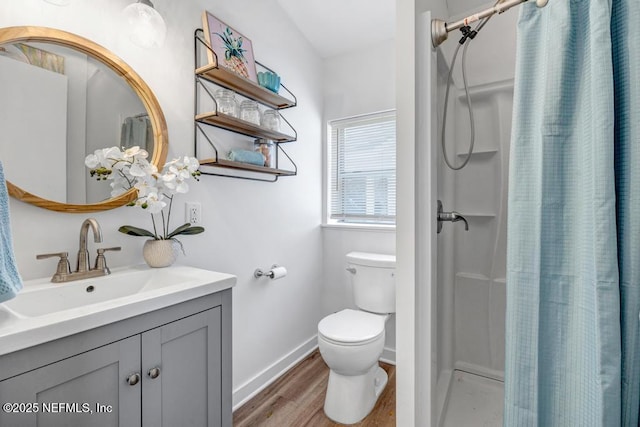 full bath featuring toilet, curtained shower, wood finished floors, baseboards, and vanity