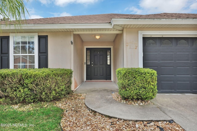 property entrance featuring an attached garage and a shingled roof