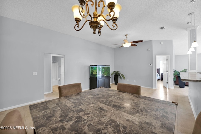 dining room with light tile patterned floors, ceiling fan with notable chandelier, visible vents, and a textured ceiling