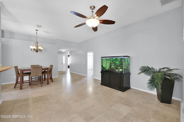 dining space featuring visible vents, ceiling fan with notable chandelier, a textured ceiling, and baseboards