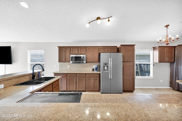 kitchen with plenty of natural light, tasteful backsplash, appliances with stainless steel finishes, and a sink