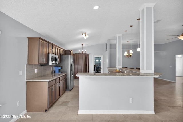 kitchen featuring lofted ceiling, stainless steel appliances, decorative backsplash, a textured ceiling, and ceiling fan with notable chandelier