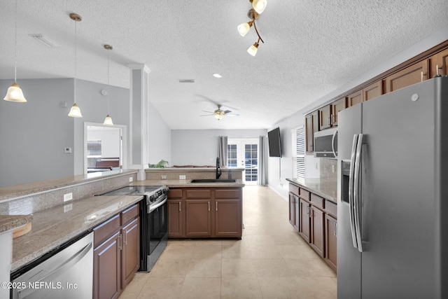 kitchen featuring visible vents, pendant lighting, a sink, light stone counters, and stainless steel appliances