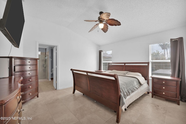 bedroom with ceiling fan, lofted ceiling, ensuite bath, and a textured ceiling