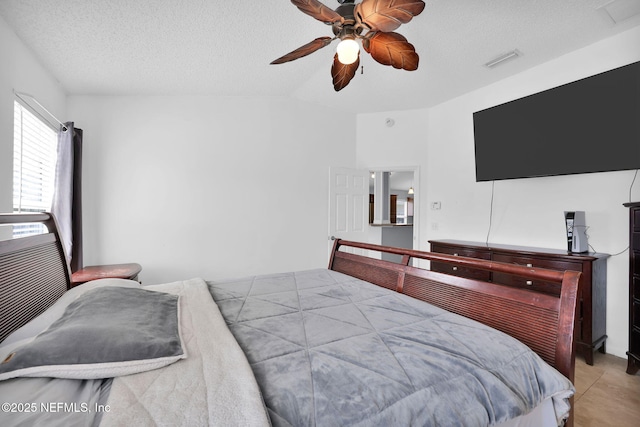 bedroom featuring visible vents, a textured ceiling, and a ceiling fan