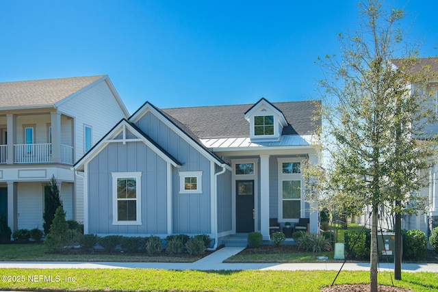 view of front of home featuring board and batten siding, a porch, roof with shingles, metal roof, and a standing seam roof