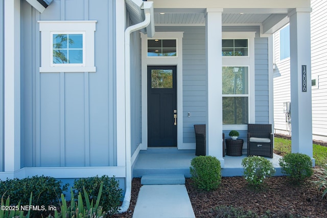 entrance to property with board and batten siding and a porch