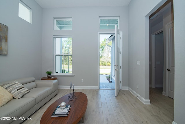 living room featuring a wealth of natural light, baseboards, and light wood-style floors