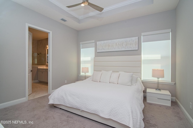 bedroom with baseboards, visible vents, carpet floors, ensuite bath, and a raised ceiling