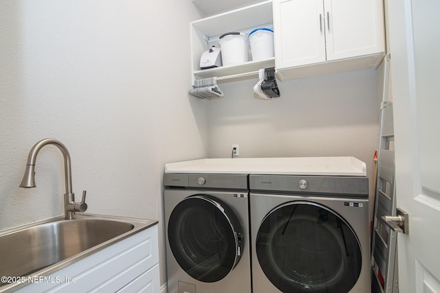 laundry room featuring cabinet space, independent washer and dryer, and a sink