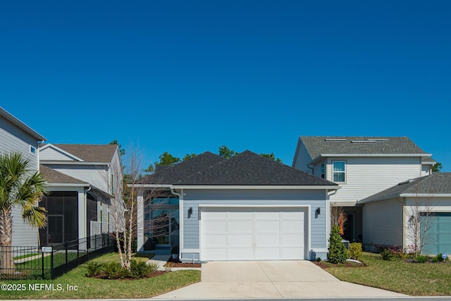 view of front of house featuring a shingled roof, a front lawn, fence, concrete driveway, and an attached garage