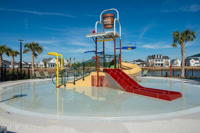 communal playground with a residential view and fence