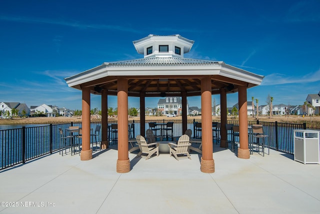 view of patio / terrace featuring a gazebo, outdoor dry bar, and a water view