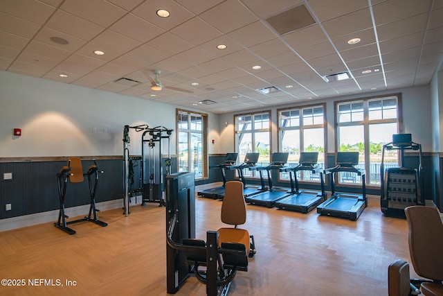 gym featuring visible vents, a wainscoted wall, and a wealth of natural light