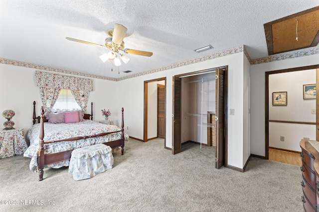 bedroom with visible vents, light colored carpet, a textured ceiling, and baseboards