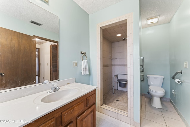 bathroom featuring tile patterned floors, visible vents, a stall shower, a textured ceiling, and vanity