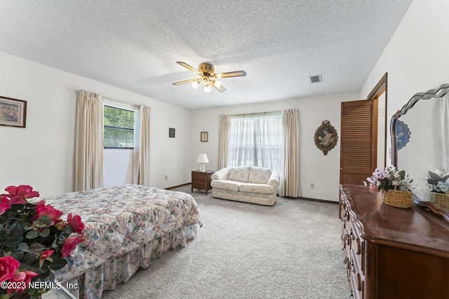 bedroom with visible vents, multiple windows, a ceiling fan, and carpet flooring