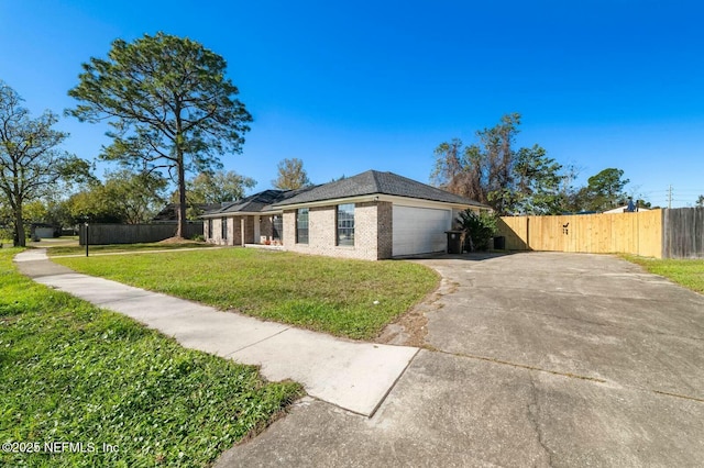 view of side of property featuring fence, a garage, a lawn, and brick siding