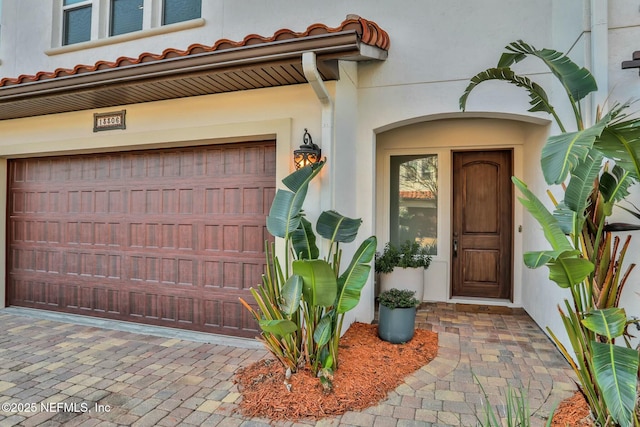 property entrance with driveway and stucco siding