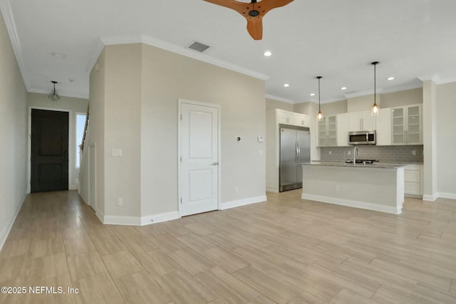 unfurnished living room with visible vents, baseboards, and a sink