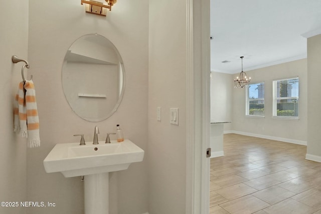 bathroom with an inviting chandelier, baseboards, and ornamental molding