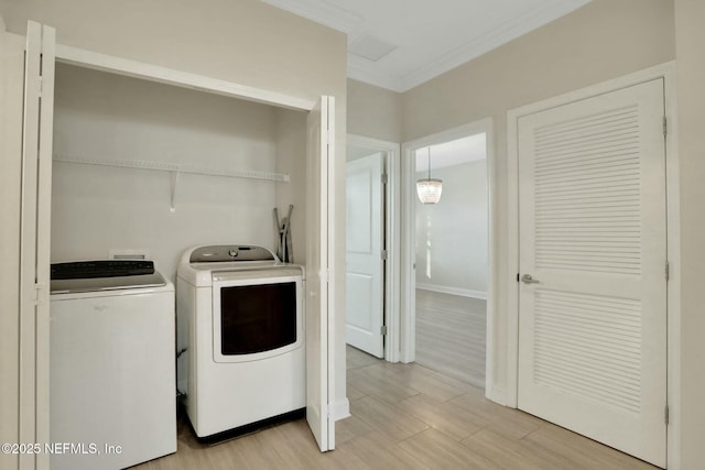 washroom featuring light wood finished floors, laundry area, independent washer and dryer, and crown molding